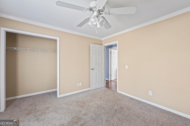 unfurnished bedroom featuring carpet floors, a closet, ornamental molding, and baseboards