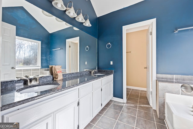 full bathroom with vaulted ceiling, double vanity, tile patterned flooring, and a sink