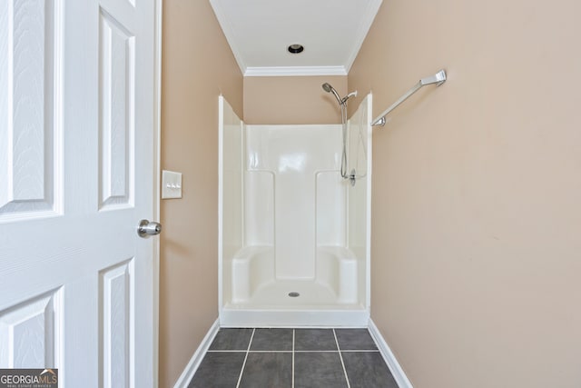 full bathroom featuring crown molding, baseboards, walk in shower, and tile patterned floors