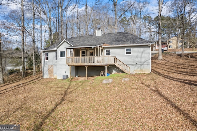 back of property featuring a chimney, stairway, a yard, a wooden deck, and central air condition unit