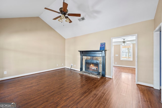 unfurnished living room featuring baseboards, visible vents, dark wood-style flooring, vaulted ceiling, and a fireplace