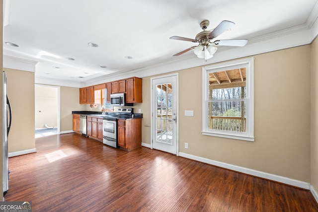 kitchen featuring appliances with stainless steel finishes, dark wood-style flooring, brown cabinetry, and baseboards