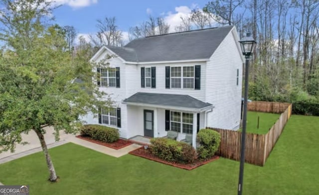 view of front of property featuring covered porch, a front lawn, and fence