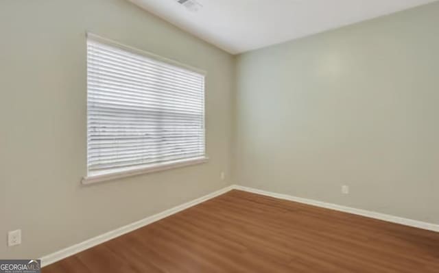 unfurnished room featuring baseboards and wood finished floors