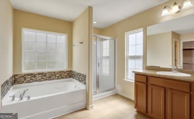 bathroom with a bath, a stall shower, a wealth of natural light, and vanity