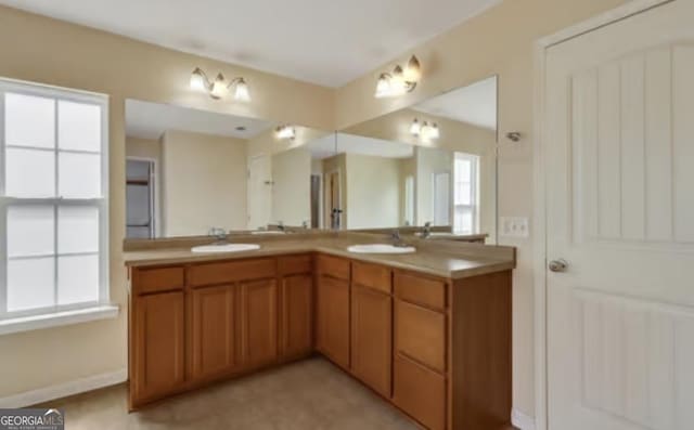 full bathroom with double vanity, baseboards, and a sink