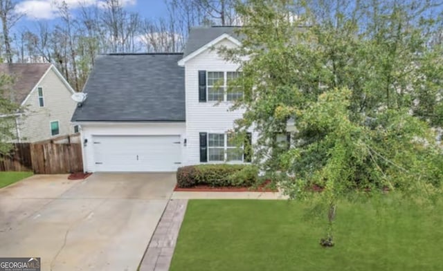 view of front facade featuring a garage, driveway, fence, and a front yard