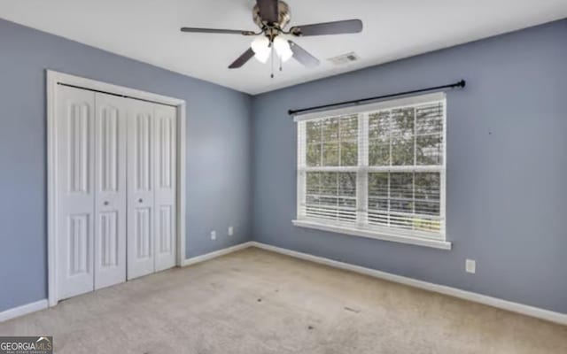 unfurnished bedroom with carpet floors, a ceiling fan, baseboards, and a closet