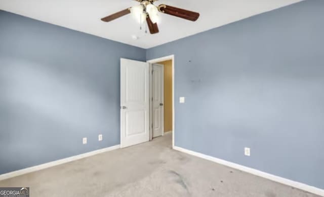 empty room featuring carpet floors, ceiling fan, and baseboards