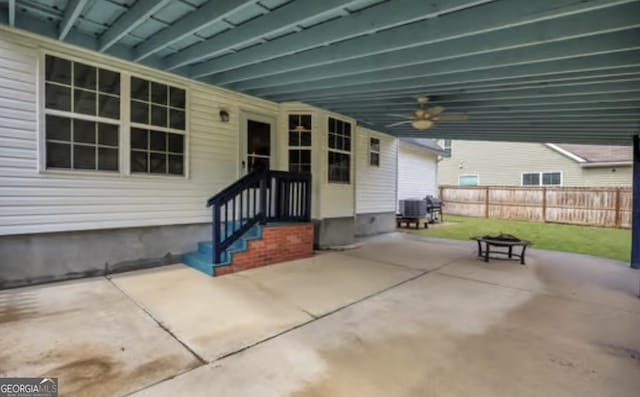 view of patio with entry steps, an outdoor fire pit, central AC unit, ceiling fan, and fence