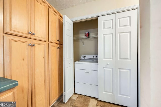 laundry room featuring a textured ceiling, laundry area, and washer / clothes dryer