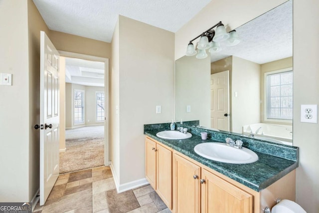 bathroom with plenty of natural light, a textured ceiling, and a sink