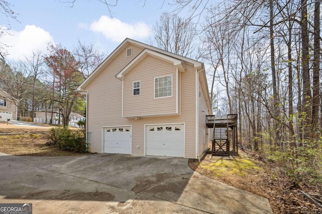 view of property exterior with a garage, stairway, and concrete driveway