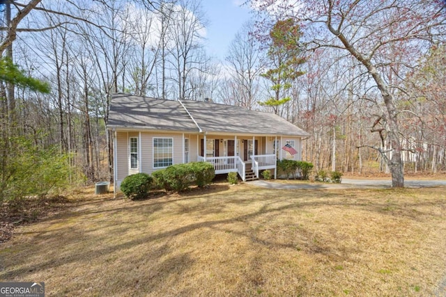 view of front of property with covered porch, central AC, and a front yard