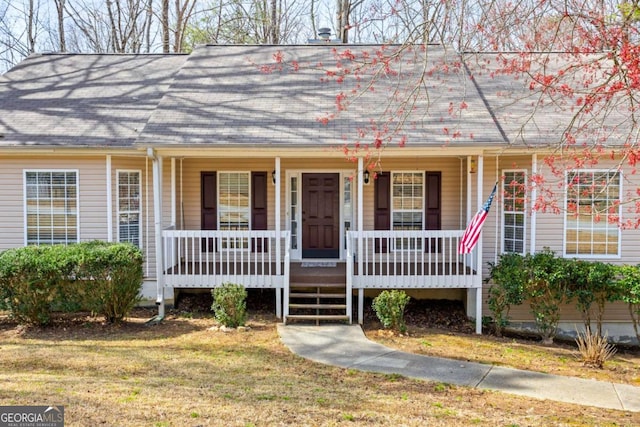 view of front of property with covered porch and a front lawn