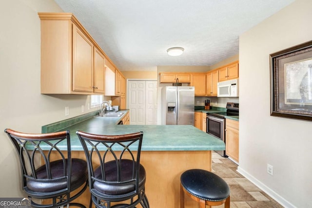 kitchen with a sink, stainless steel appliances, a peninsula, and light brown cabinets