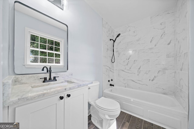 bathroom featuring toilet, wood tiled floor, tub / shower combination, and vanity