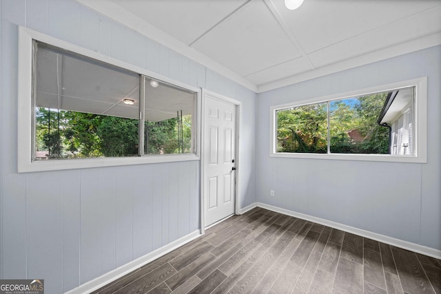 spare room featuring baseboards and dark wood finished floors