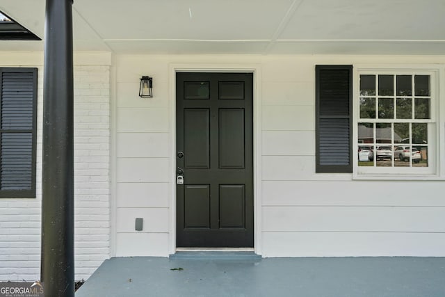 view of exterior entry with brick siding