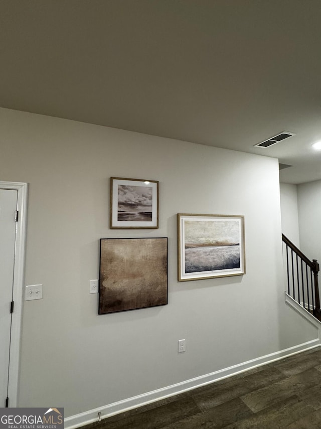 interior space with visible vents, dark wood finished floors, stairway, and baseboards