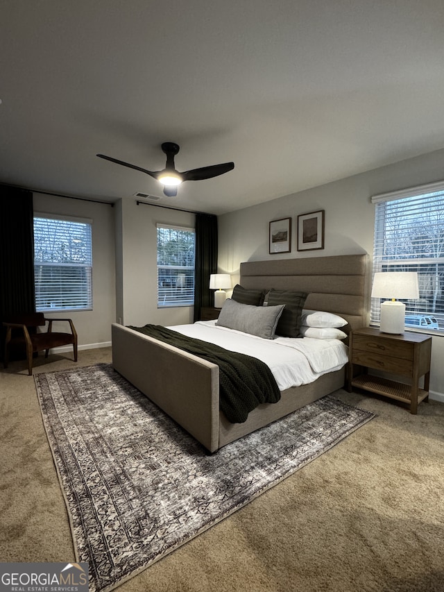 carpeted bedroom featuring visible vents, baseboards, and a ceiling fan