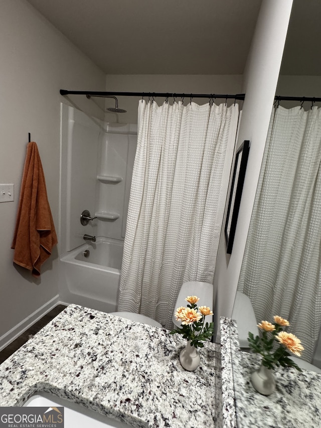 full bathroom with baseboards and shower / bathtub combination with curtain