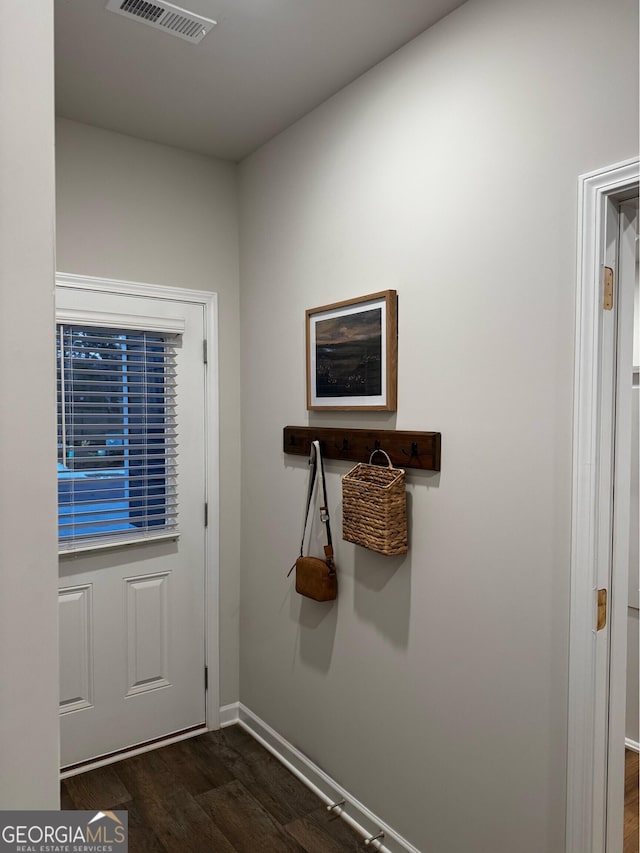 entryway featuring dark wood-type flooring, visible vents, and baseboards