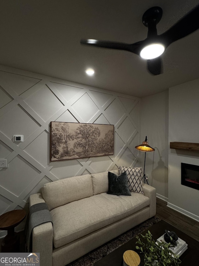 living room featuring a fireplace, baseboards, and wood finished floors