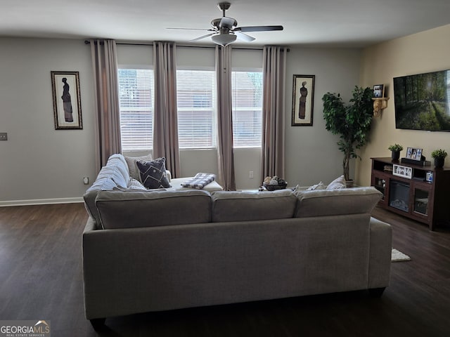 living area featuring baseboards, ceiling fan, and dark wood-style flooring