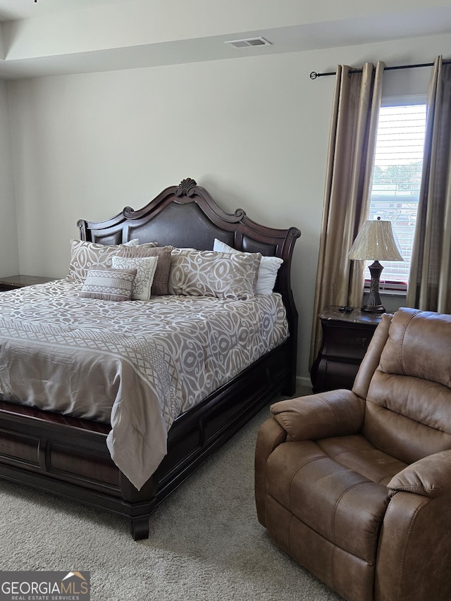 carpeted bedroom featuring visible vents