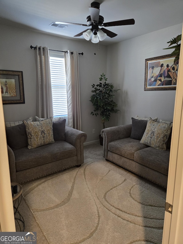 carpeted living room with baseboards, visible vents, and ceiling fan