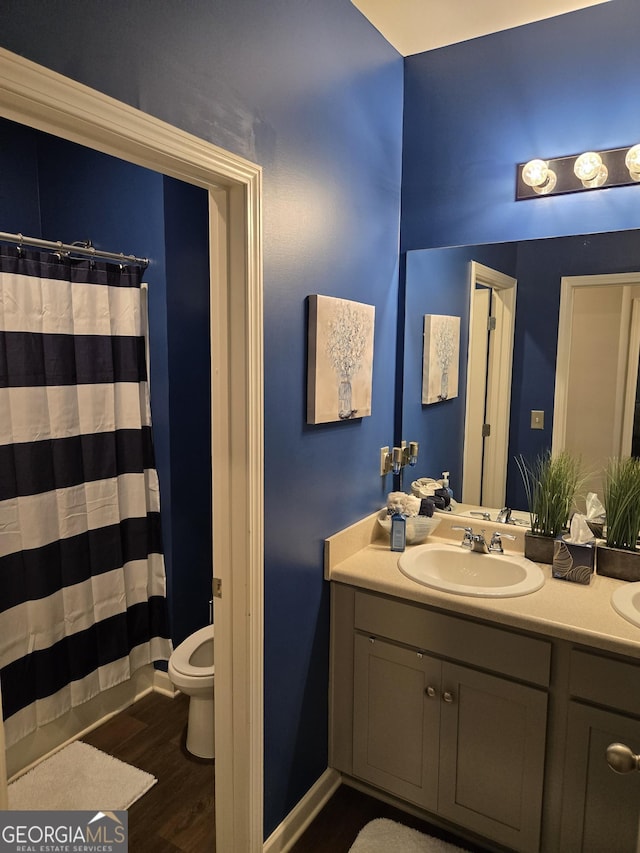 bathroom featuring vanity, curtained shower, toilet, and wood finished floors