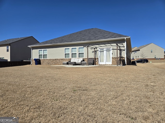 rear view of house with a yard, brick siding, and an outdoor hangout area