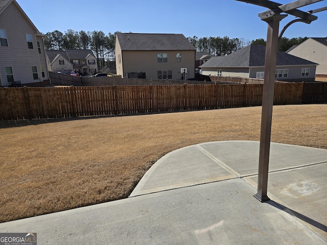 view of yard with a residential view, a patio, and fence