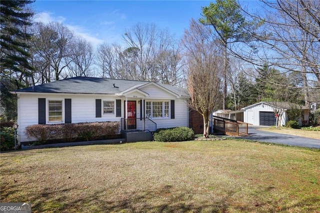 ranch-style home with a garage, aphalt driveway, a front lawn, and an outdoor structure