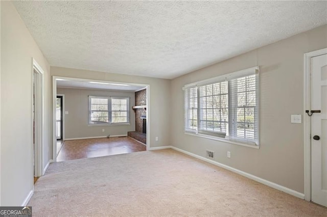5812 Dogwood Cir, Austell, GA 30168 - unfurnished living room featuring carpet floors, a brick fireplace, and a textured ceiling