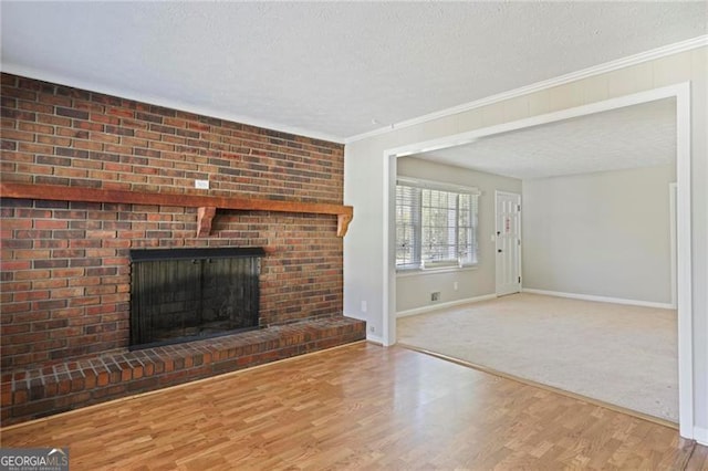 5812 Dogwood Cir, Austell, GA 30168 - unfurnished living room with a fireplace, a textured ceiling, wood finished floors, and crown molding
