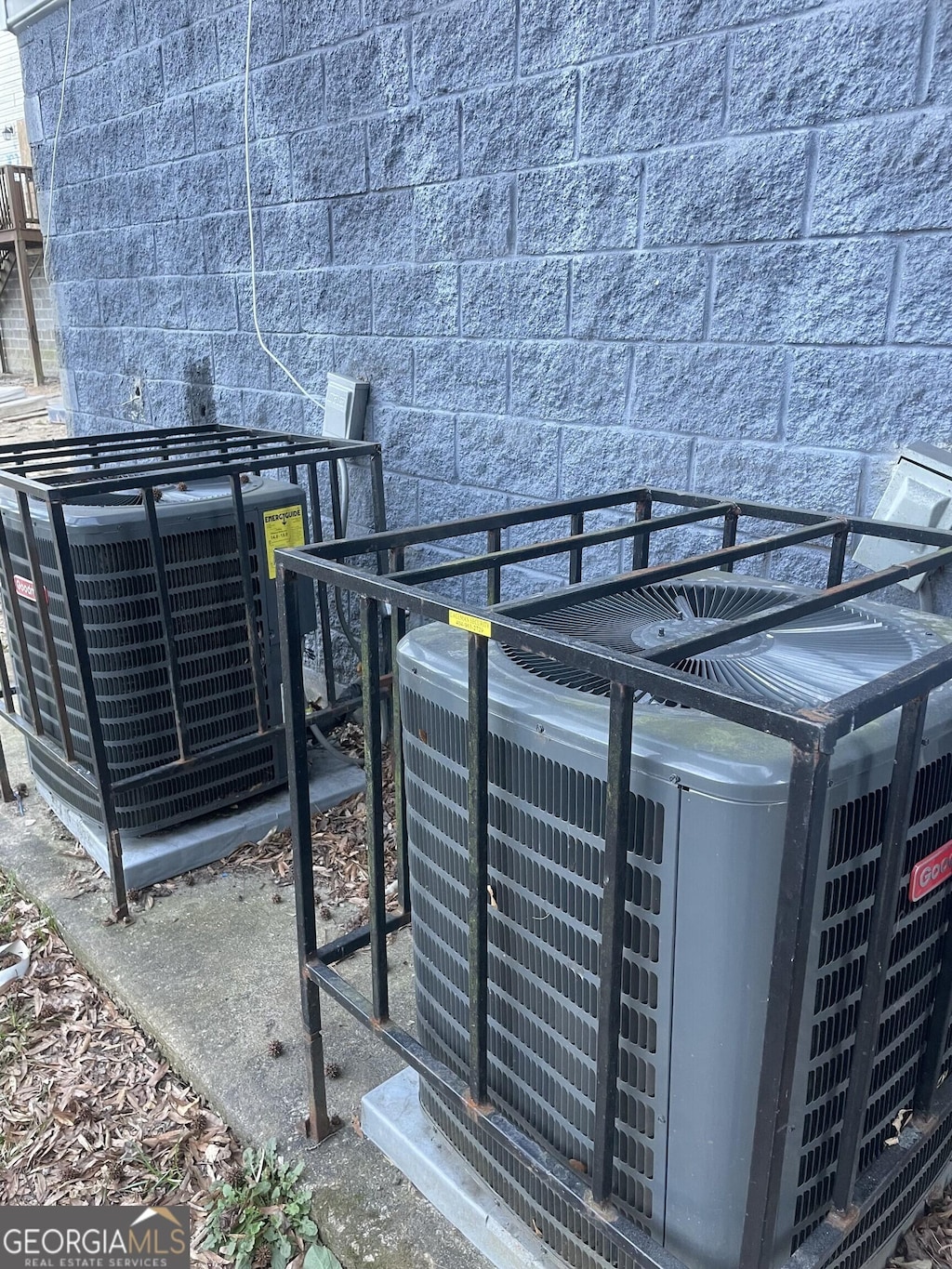 exterior details featuring concrete block siding and central AC unit