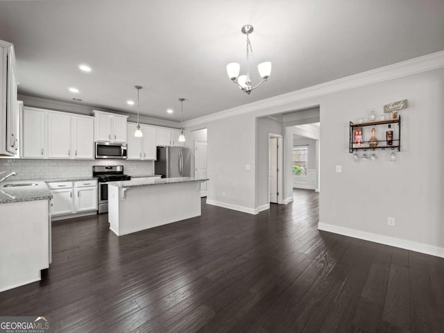 kitchen featuring stainless steel appliances, a center island, a sink, and backsplash