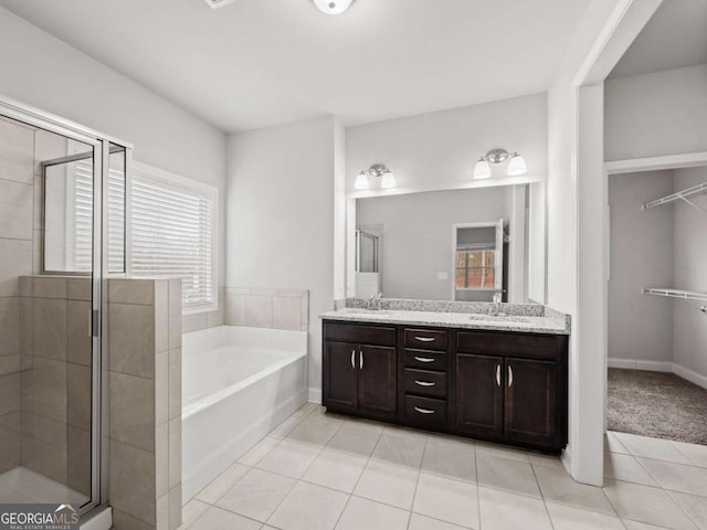 full bathroom featuring double vanity, a sink, a shower stall, and a bath