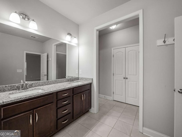 full bathroom featuring double vanity, a sink, visible vents, and tile patterned floors