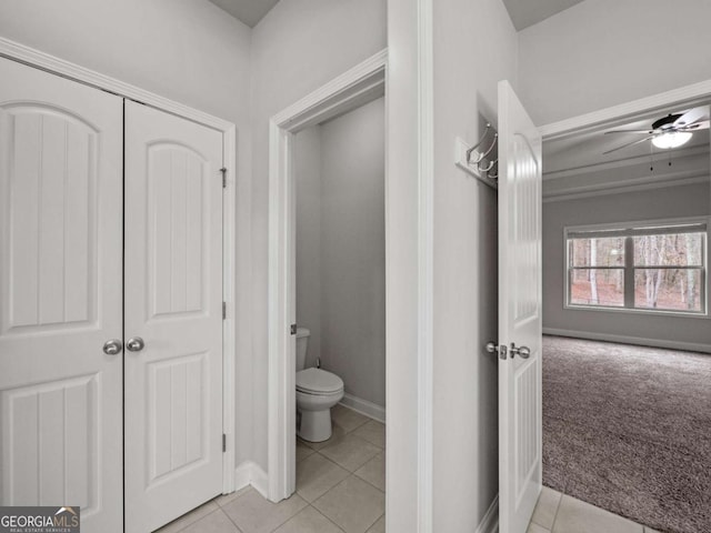 bathroom featuring toilet, tile patterned flooring, and baseboards