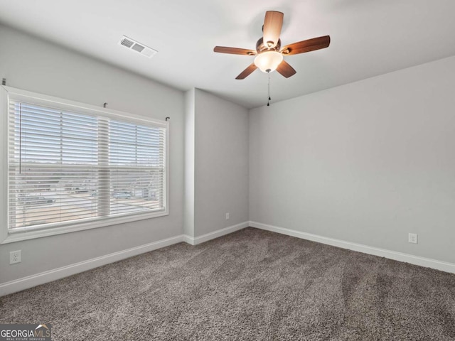 empty room with baseboards, visible vents, ceiling fan, and carpet flooring