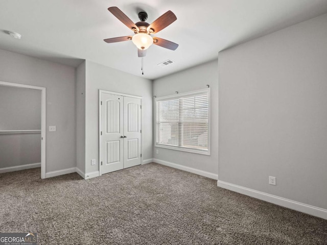 unfurnished bedroom with carpet floors, a ceiling fan, visible vents, baseboards, and a closet