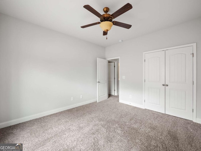 unfurnished bedroom with carpet floors, a closet, a ceiling fan, and baseboards