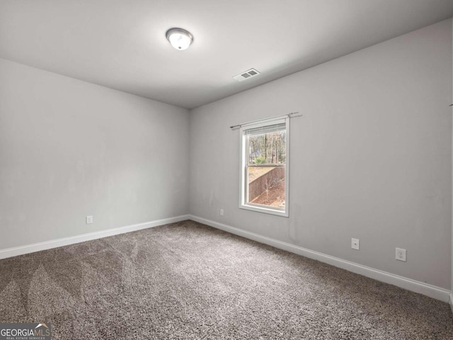 unfurnished room featuring baseboards, visible vents, and carpet flooring