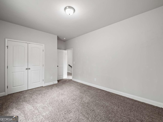 unfurnished bedroom featuring carpet, baseboards, and a closet