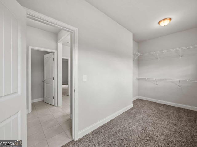 walk in closet featuring light tile patterned flooring and light colored carpet