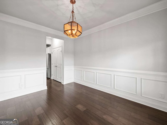 unfurnished dining area featuring crown molding, wainscoting, and dark wood finished floors