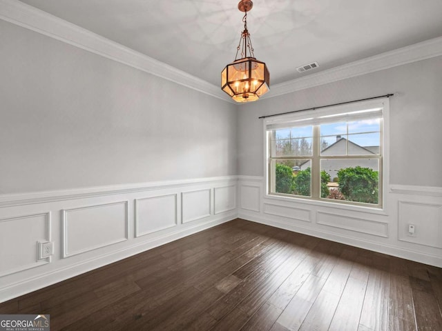 unfurnished dining area featuring dark wood-type flooring, visible vents, ornamental molding, and a notable chandelier